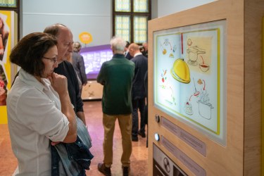 Two adults look at an interactive exhibit about food