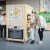 Little girl & woman near a fridge-shaped exhibit